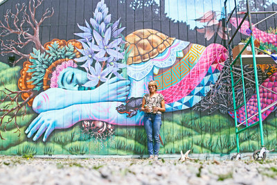 Ila Rose with her first public mural in the Whiteaker at 5th Alley and Blair Boulevard. Photo by Athena Delene.