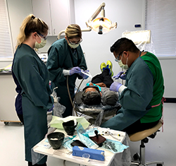dental assisting students with instructor and patient