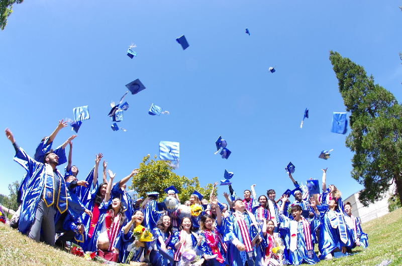 Students doing a graduation cap toss