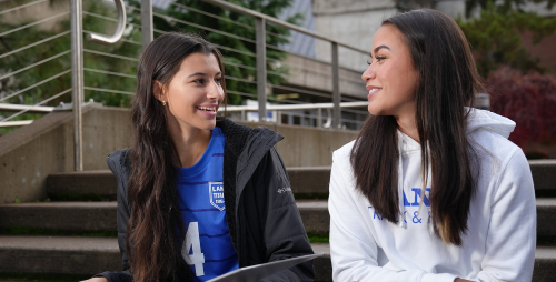 two student athletes smiling and talking