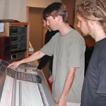 students working with recording studio sound mixing board