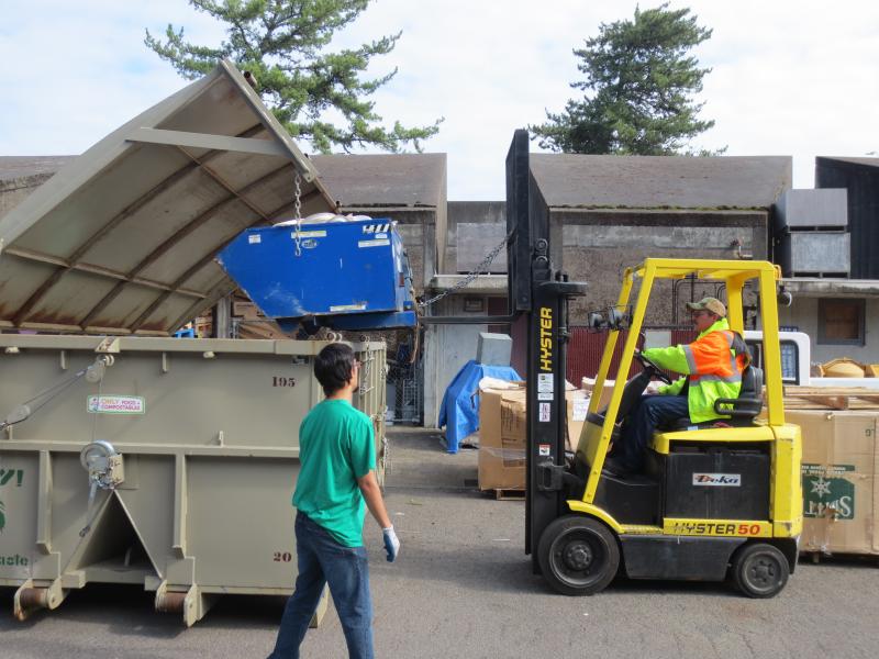 dumping the hopper into the 20 yard container for trucking to Rexius