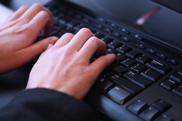 a close up of a person typing at a keyboard