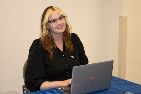 a Lane HR intern smiles and works at a laptop
