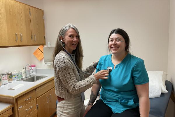 A friendly nurse checks the pulse of a student in the LCC Health Clinic