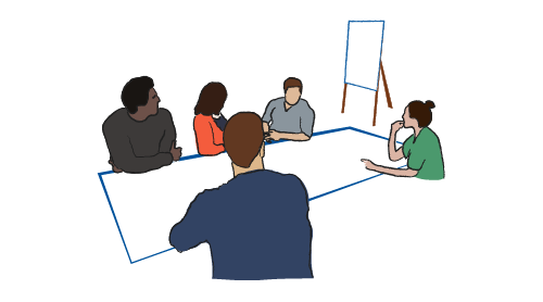Diverse faculty discuss ideas at a table with a whiteboard in the background