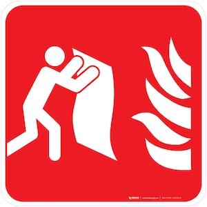a red and white pictogram showing a person holding a blanket toward flames, indicating a fire blanket location