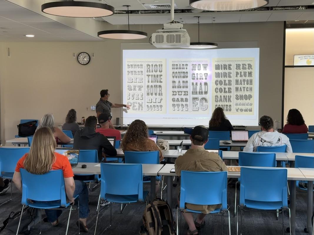 Tom Madison, a graphic designer, instructs high school CTE art teachers on typography