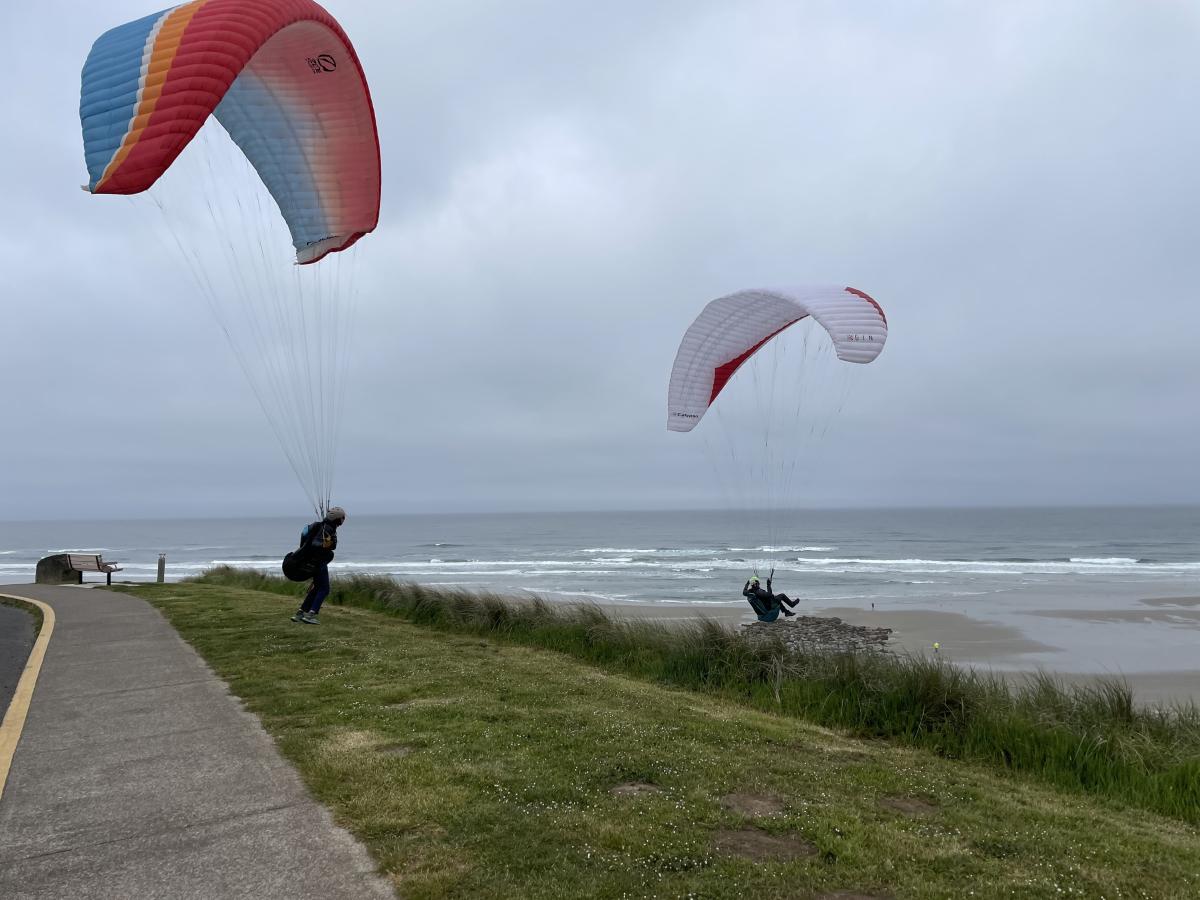 Two paragliders on a coastal, northwest looking beach