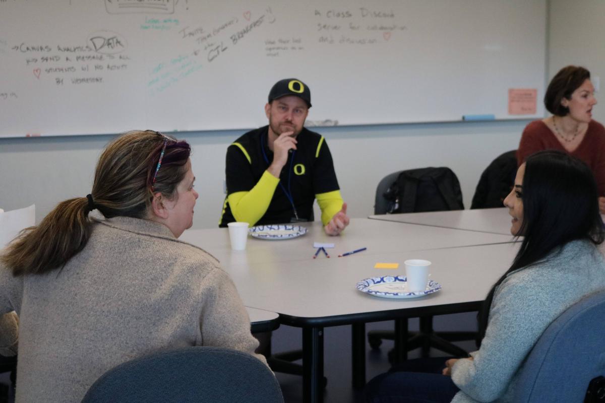 Breakfast participants sharing conversation around a table with coffee cups and plates.