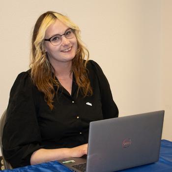 a Lane HR intern smiles and works at a laptop