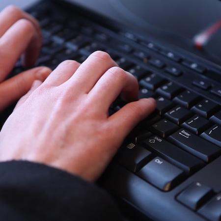 a close up of a person typing at a keyboard